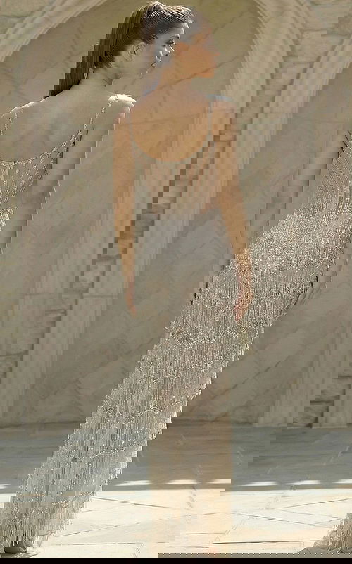 Back view of beaded gown with sheer corset detail and layered fringe skirt