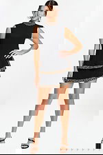 Sleeveless black mini dress with beaded high neckline and layered skirt