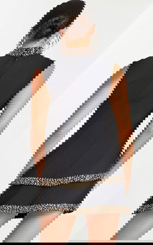 Back view of black mini dress with tiered skirt and beaded trim