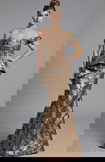 Front view of off shoulder mermaid gown with sculpted bodice, peplum detail, and metallic floral brocade