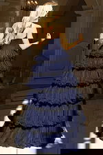 Strapless tiered tulle gown with layered ruffles and high slit