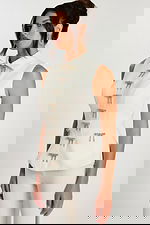 Close-up side angle showing rhinestone bow details on ivory tailored top