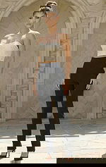 Woman wearing a structured two piece jumpsuit with cropped bodice and tailored pants