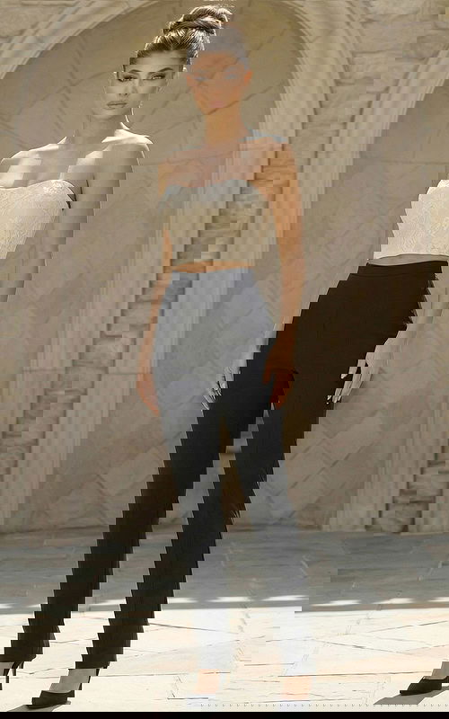 Woman wearing a structured two piece jumpsuit with cropped bodice and tailored pants