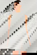 Close-up of high neckline and layered flower details on white satin dress