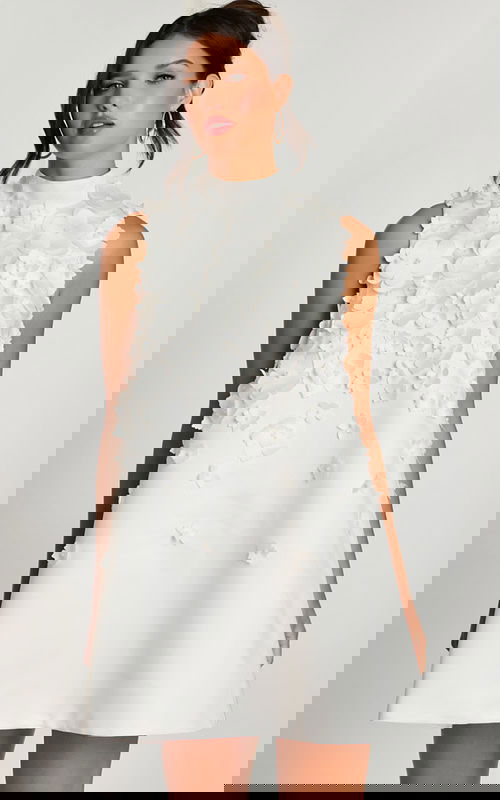 Close-up of high neckline and layered flower details on white satin dress