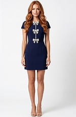 Short fitted dress with bow embellished front and cap sleeves