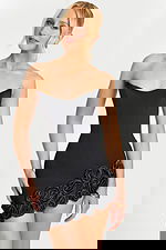 Model wearing fitted black dress with sculpted floral appliqué