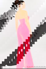 Rear side view of red fitted jumpsuit showing flared pant and open back