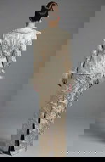 Back view of structured brocade jacket and fitted long skirt with slit