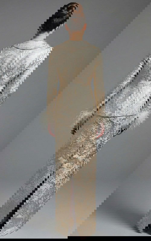 Back view of structured brocade jacket and fitted long skirt with slit