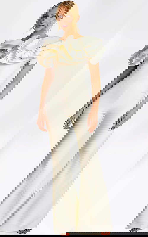 Elegant white jumpsuit with dramatic ruffled shoulders and pearl safety pin accents