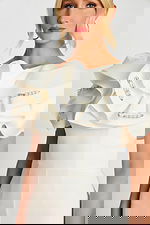 Front close-up of white jumpsuit highlighting textured ruffles and embellishments