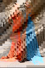 Two models wearing shimmer gowns in orange and teal with thigh-high slits