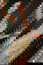 Beaded gold evening dress featuring cascading fringe details and slit