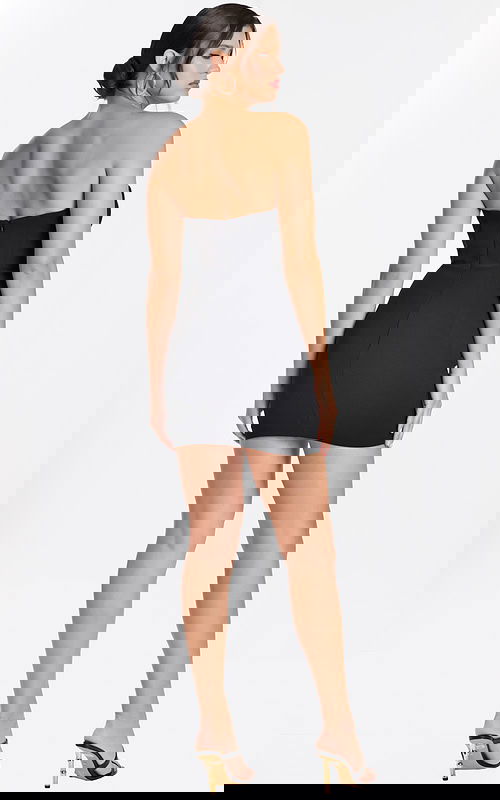 Back view of strapless black mini dress with exposed zipper and sleek fit