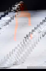 Strapless floor length gown with a smooth fitted bodice, soft draping, and an oversized bow detail at the waist creating a clean, elegant silhouette