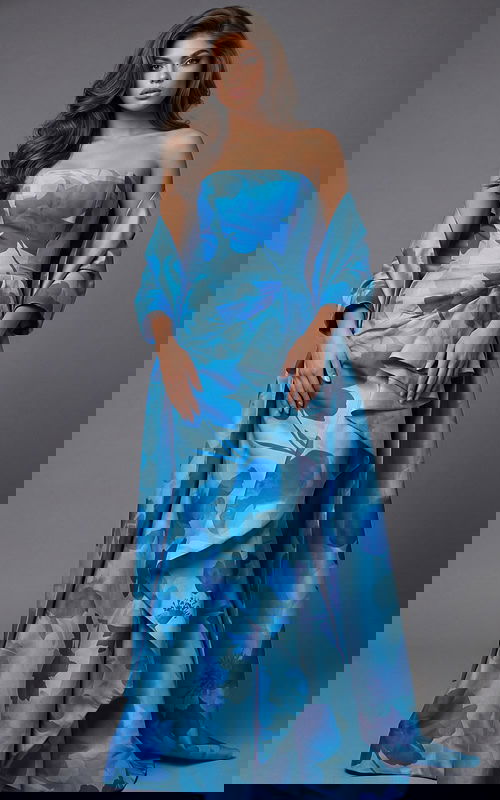 Front view of strapless printed gown with structured bodice, cascading ruffle detail, and matching draped wrap