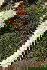 Model wearing sheer corset gown with beaded pattern and side slit