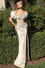 Model wearing sheer corset gown with beaded pattern and side slit