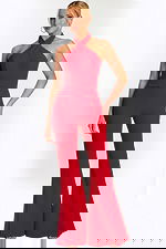 Woman wearing a red halter-neck jumpsuit with wide-leg pants, front view