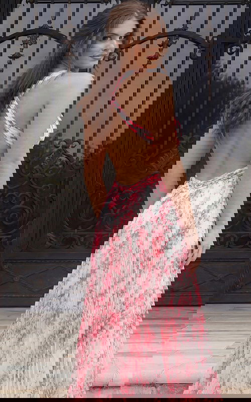 Floral pleated evening dress with open back and crossed straps flowing into a soft A line skirt