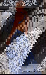 Floral pleated evening dress with open back and crossed straps flowing into a soft A line skirt