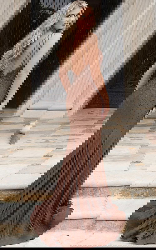 Back view of a beaded column gown with open back and flowing train