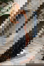 Black strapless evening gown with fitted bodice and flowing skirt embellished with three-dimensional circular appliqués