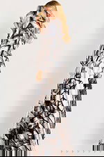 Long-sleeve maxi dress with a high neckline and bold botanical print, featuring a flowy silhouette and soft drape.