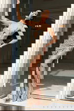 Side view of embellished fitted gown with thigh-high slit