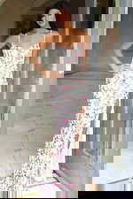 Model wearing floral embroidered gown with sweetheart neckline and slit