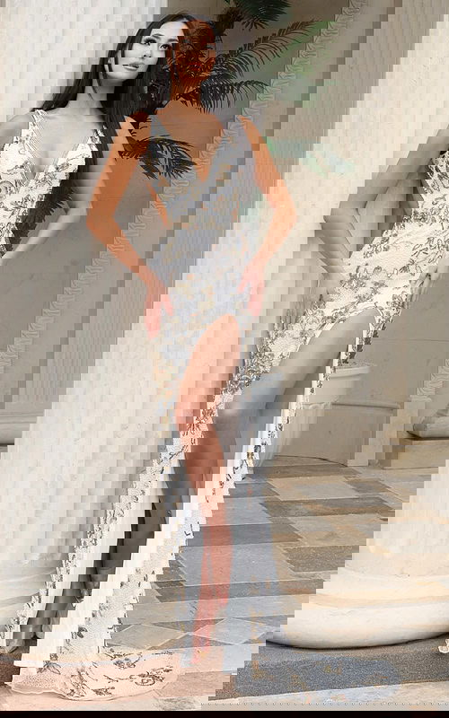 Form-fitting white gown with gold beaded floral embellishments, plunging V-neckline, open back, and leg slit