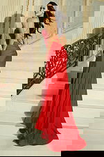 Woman wearing a fitted gown with sweetheart neckline, halter straps, and thigh high slit