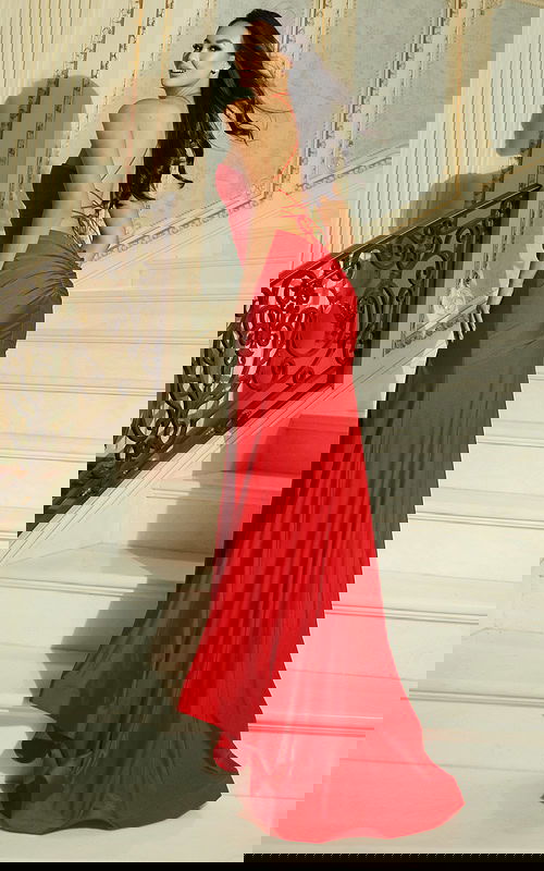 Woman wearing a fitted gown with sweetheart neckline, halter straps, and thigh high slit