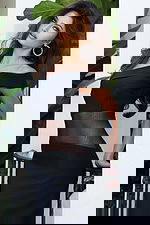 Jovani 51666 black off the shoulder bandage dress side close up showing folded neckline, sheer mesh waist panel, and structured bandage construction