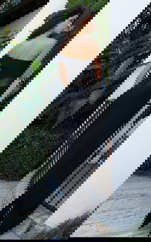 Jovani 51666 black off the shoulder fitted bandage gown back view showing folded neckline, sheer mesh waist panel, zipper closure, and floor length column silhouette