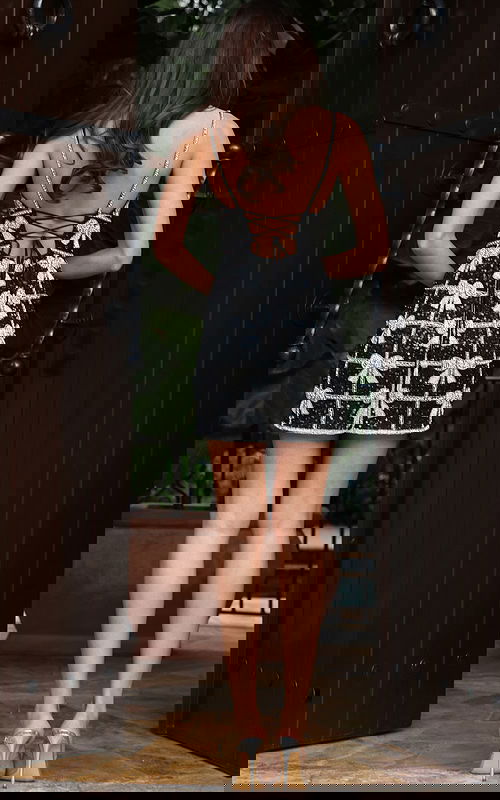 Jovani 52449 black and silver short dress back view showing open back with lace up tie closure, crystal embellished spaghetti straps, and beaded bow motif grid pattern