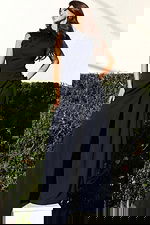 Jovani 53168 navy sleeveless high neck jumpsuit side view showing 3D floral appliques cascading from the neckline to the hip, with draped wide leg pants