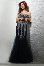 Model wearing Jovani 5908 navy mermaid gown with intricate beading