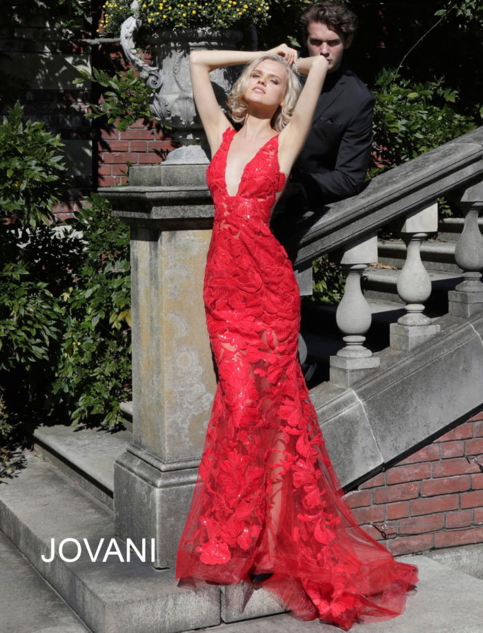 Model wearing Jovani 60283 in red, side view showing lace appliques.