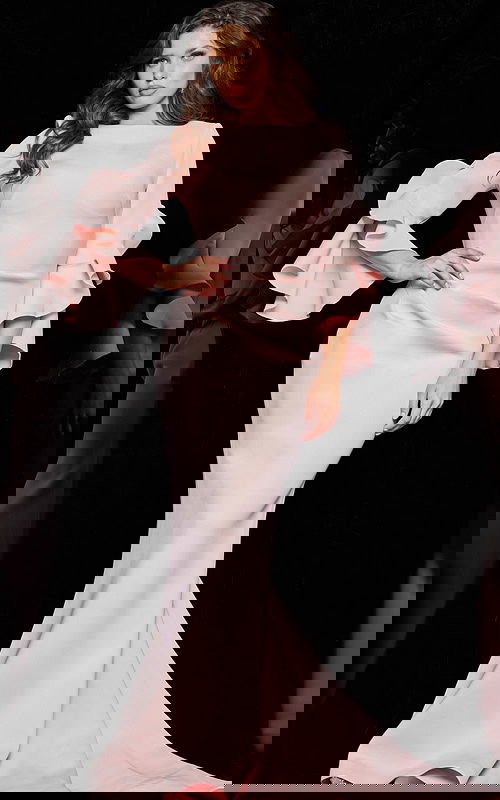 Model wearing Jovani 63168 blush dress with mermaid silhouette and tiered bell sleeves.