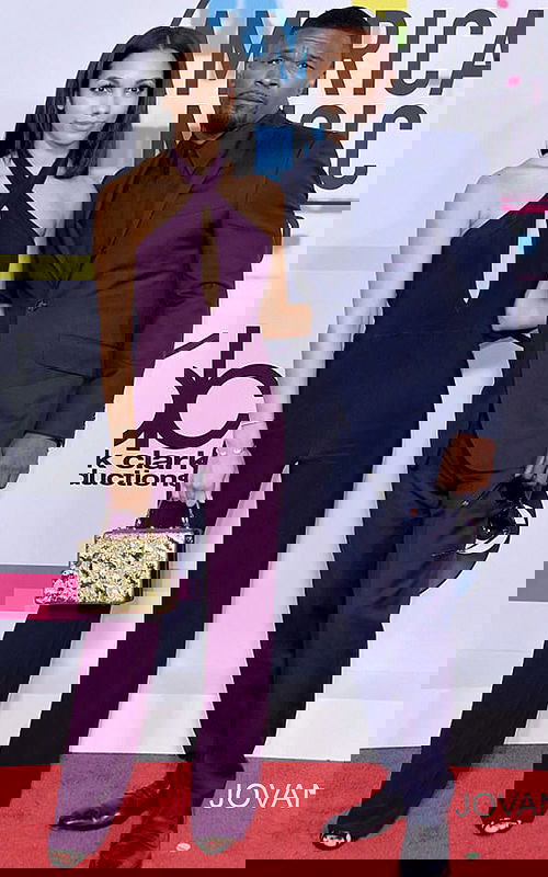 Model wearing Jovani 50908 dress with a halter neckline and keyhole cutout, full-length in purple, standing next to a companion.