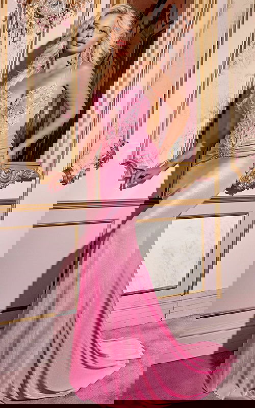 Model wearing Jovani D5046 elegant pink gown with floral embellishments from the front.