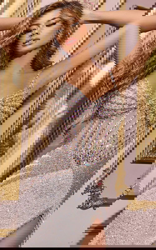 Model wearing Jovani D5601 white gown with embellishments and high slit, front view.