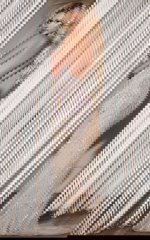 Model displaying open back of Jovani D5701 silver dress with shimmering embellishments.