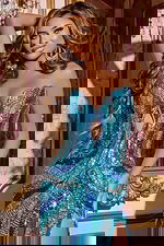 Model wearing Jovani D5715 blue dress with intricate design and high slit.