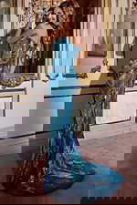 Model showing the back of Jovani D5715 blue dress with a glamorous train.