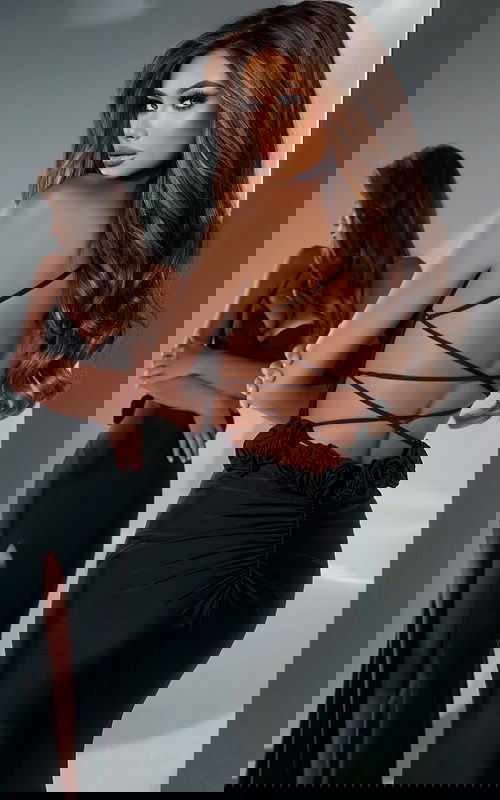 Detailed back of Jovani D5821 black dress with open strap design.