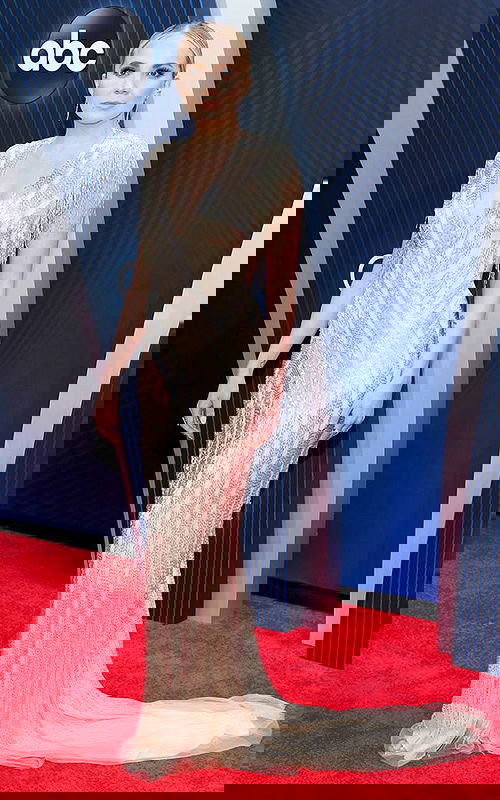 Model wearing Jovani 40900 in a floor-length nude gown with a V-neckline and embellished short sleeves.